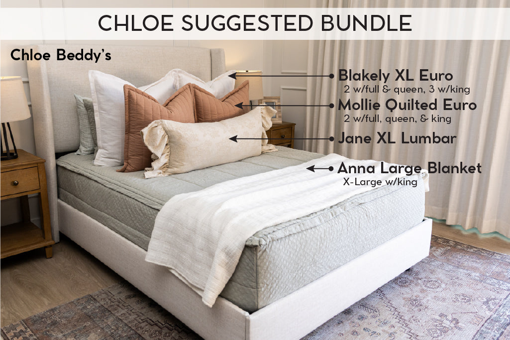 A twin bed made with soft green zipper bedding and pink and multi-color floral pattern pillows and blanket.