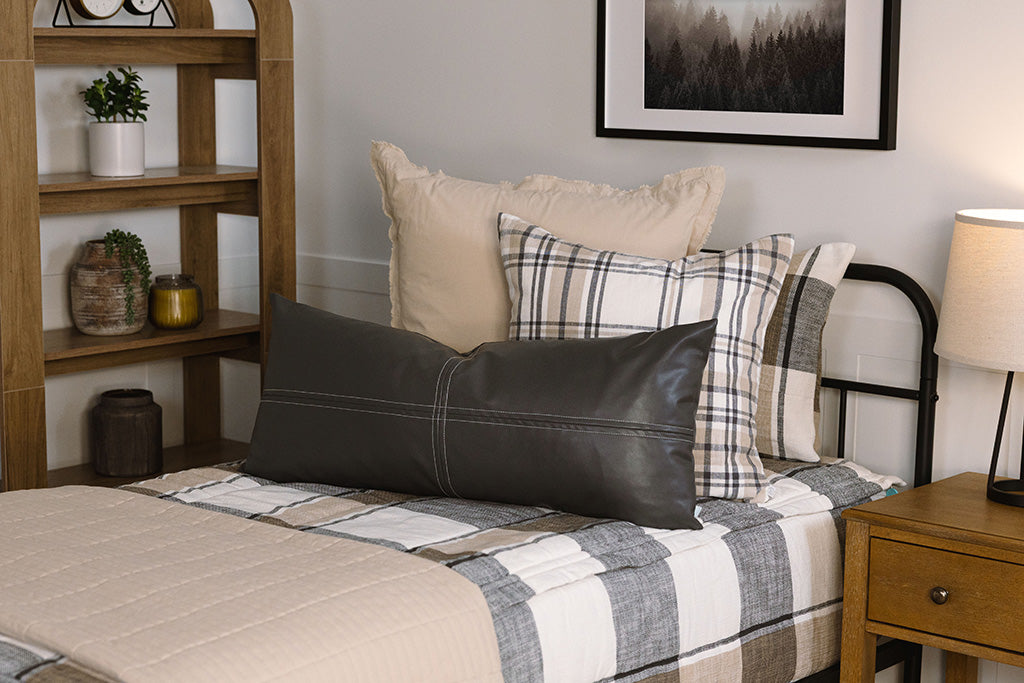 A close up side view of a bed made with cream, tan, and charcoal plaid zipper bedding.