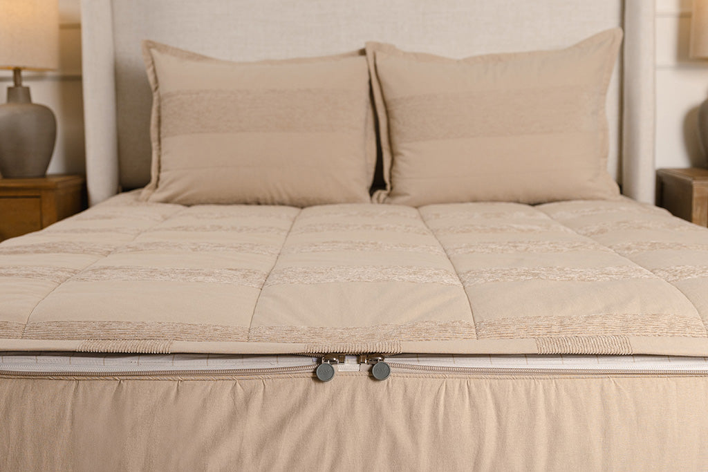 A close up of the texture and striped pattern on tan zipper bedding.